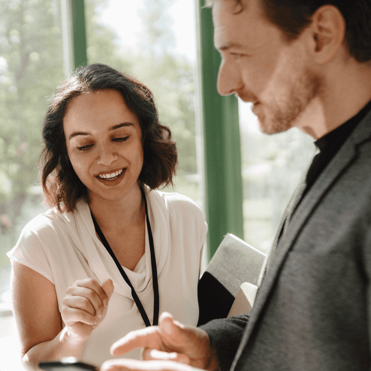 Image of a woman and man looking at a smart device.